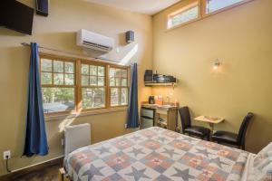 a bedroom with a bed and a desk and a window at Creekside Cowa-Bungalow - 61 E 200 - Studio in Moab