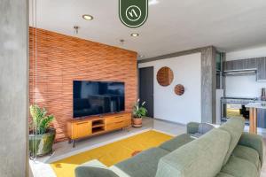 a living room with a couch and a flat screen tv at 3 BR Condo - Panoramic Views - 5 Min to Downtown in Oaxaca City