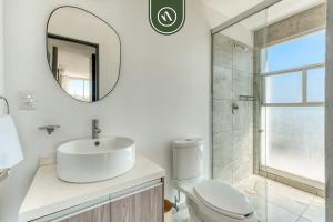 a white bathroom with a sink and a mirror at 3 BR Condo - Panoramic Views - 5 Min to Downtown in Oaxaca City +25 photos