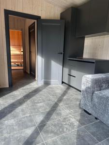 a kitchen with a tiled floor and a couch at Sauna & stay in Engure