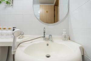 a bathroom with a white sink and a mirror at Metro Stay Daejeon Cozy home at transport hub in Daejeon +59 photos