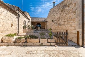 an alley with stone buildings and stairs with a gate at Agriturismo Al Casale in Donnafugata