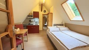 エンツクレスターレにあるSchwarzwaldhaus Zwinkのベッドとテーブルとキッチンのある寝室