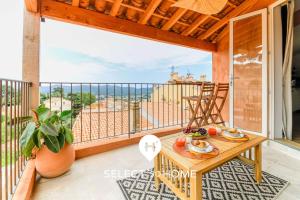 a balcony with a table and a view of the ocean at SELECT'soHOME - Duplex avec terrasse au cœur du village de Bormes-les-mimosas ! - IRUNDA in Bormes-les-Mimosas