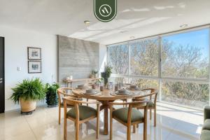 a dining room with a table and chairs and a large window at 3 BR Condo - Panoramic Views - 5 Min to Downtown in Oaxaca City