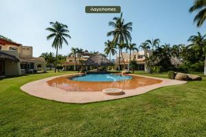 une piscine au milieu d'une cour avec des palmiers dans l'établissement Amazing House -Private Pool - Tennis - Paddle Cour, à Acapulco