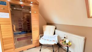 エンツクレスターレにあるSchwarzwaldhaus Zwinkのガラスのキャビネットの隣に置かれた白い椅子 +63枚の写真