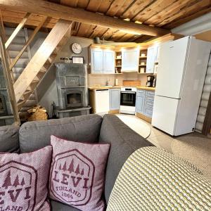 un soggiorno con divano e cucina di Tunnelmallinen hirsimökki - Levin Liitäjä a Kittilä