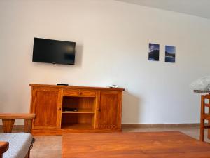 a living room with a flat screen tv on a wall at Apartamentos Jardín del Conde in Valle Gran Rey