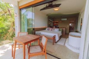 Un dormitorio con una cama y una mesa y sillas. en Casa Natu Ilhabela Mirante, en Ilhabela