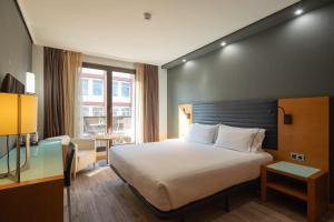 a hotel room with a bed and a window at Eurostars Indautxu in Bilbao