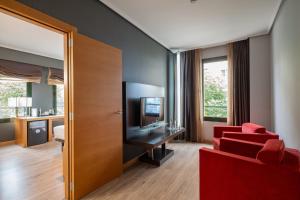 a living room with a red couch and a television at Eurostars Indautxu in Bilbao