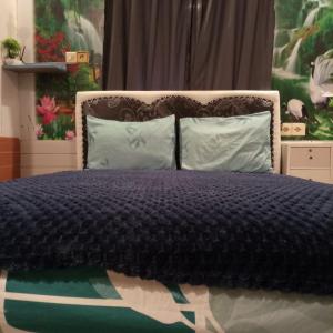 a bed with a black comforter and two pillows at Waru Homestay Gili Gede in Gili Gede