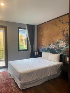 a bedroom with a large bed with a painting on the wall at Căn hộ khách sạn wyndham Thanh Thuỷ in La Phu