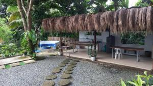 une petite maison avec une table et un banc dans l'établissement Vista Linda Farmstaycation, à Alitagtag 6 autres photos