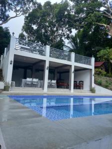 une maison avec une piscine devant dans l'établissement Vista Linda Farmstaycation, à Alitagtag