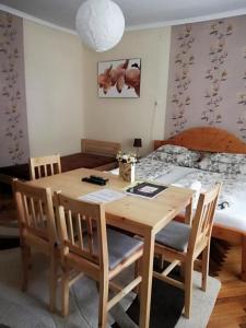 - une table à manger avec des chaises et un lit dans l'établissement Csilla Apartman, à Makó