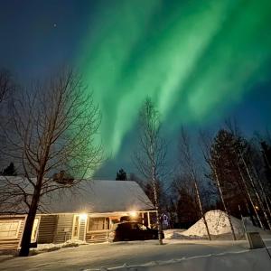 un'immagine dell'aurora boreale sopra una casa di Tunnelmallinen hirsimökki - Levin Liitäjä a Kittilä