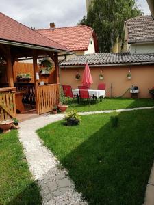 un patio avec une table et des chaises dans une cour dans l'établissement Csilla Apartman, à Makó 5 autres photos