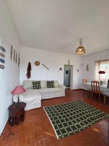a living room with a white couch and a table at Casita do avô in Carvoeira