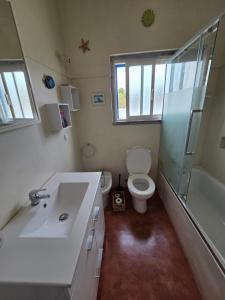 a bathroom with a sink and a toilet and a shower at Casita do avô in Carvoeira +13 photos