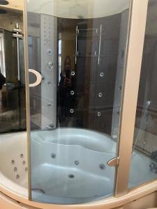 Una mujer tomando una foto de una bañera en un baño en Good Dreams Mini Otel, en Kiev