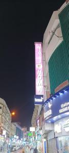 eine Stadtstraße in der Nacht mit Neonschild in der Unterkunft Homa Hotel in Dubai