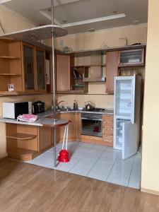 Una cocina con gabinetes de madera y un refrigerador blanco. en Good Dreams Mini Otel, en Kiev
