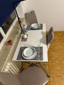 a table with two white plates on top of it at Steffies Appartement Four in Niedernhausen