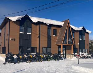 a group of motorcycles parked in the snow in front of a building at Hôtel St-Michel in Saint-Michel-des-Saints