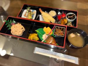 un plateau de nourriture posé sur une table dans l'établissement HOTEL ZEKU yoshida, à Yoshinaga