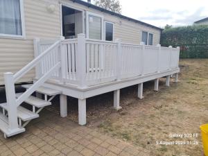 un porche blanc avec des escaliers sur une maison dans l'établissement Willerby Escapes, à Lytchett Minster