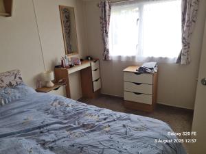 une chambre avec un lit et une fenêtre dans l'établissement Willerby Escapes, à Lytchett Minster