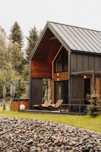 Una casa de granero con un porche y un patio en Honey House Wierchy- prywatna strefa SPA, en Jaszczurowa