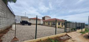 a fence with a truck parked in front of a house at Casa familiar in El Molino