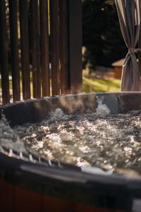 Un bebedero para pájaros con agua junto a una valla. en Honey House Wierchy- prywatna strefa SPA, en Jaszczurowa