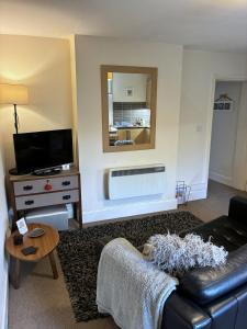 a living room with a couch and a mirror at Peel House Apartments - Great for Professionals & Weekends Away in Burton upon Trent +54 photos