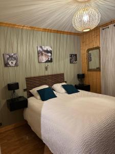 a bedroom with a large bed and a chandelier at Appartement BOZEN - 100M2- 6 personnes - Bozel - Vallée de Courchevel in Bozel