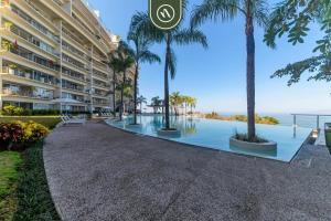 een groot appartementencomplex met een zwembad en palmbomen bij Oceanview Penthouse with Private Pool - BBQ in Puerto Vallarta