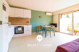 a kitchen and dining room with a table and chairs at SELECT'soHOME - Appartement pour 4 personnes - Proche plage et parking privé -PARCFO11 in Le Lavandou