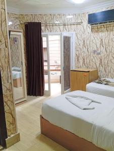 een hotelkamer met een bed en een spiegel bij Cairo Hotel فندق القاهرة in Caïro