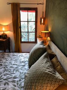 a bedroom with a bed with pillows and a window at L'étape Impressionniste in Croissy-sur-Seine
