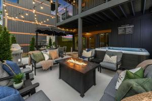 a patio with a fireplace and a hot tub at The Great Escape! Sleeps 26 - Sky Deck - Arcade - Golf - Waterpark in New Era