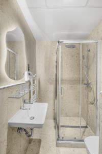 ein Badezimmer mit Dusche und Waschbecken in der Unterkunft Hotel Allora in Budapest + 79 Fotos