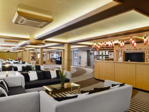 a large living room with couches and a tv at Aquaticum Debrecen Termal & Wellness Hotel in Debrecen