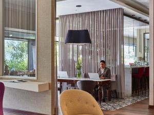 a man sitting at a table with a laptop at Manto Hotel Lima - MGallery Collection in Lima