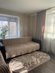 Una sala de estar con un sofá y una ventana. en Апартаменти в центрі, en Lutsk