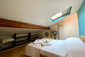 a bedroom with a white bed with towels on it at The Montpellier Escape-Duplex featuring a terraceconditioning in Montpellier +23 photos