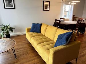 a living room with a yellow couch and a table at Atlantic Oasis in Halifax