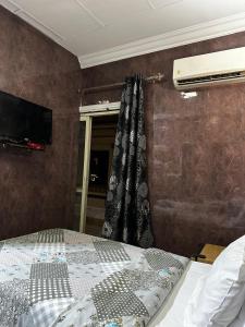 een slaapkamer met een bed, een raam en een televisie bij Cairo Hotel فندق القاهرة in Caïro